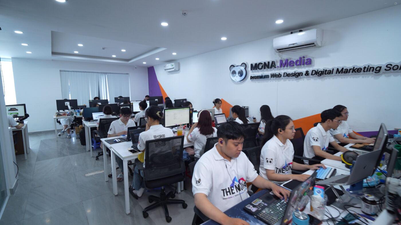 Dãy bàn làm việc dài của đội ngũ MONA Media trong văn phòng
